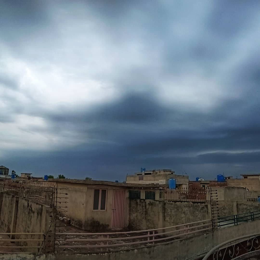 Rooftops, Heavy Sky — street photograph by Muhammad Azeem